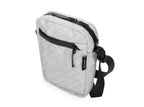 White quilted crossbody bag with black strap on a white background